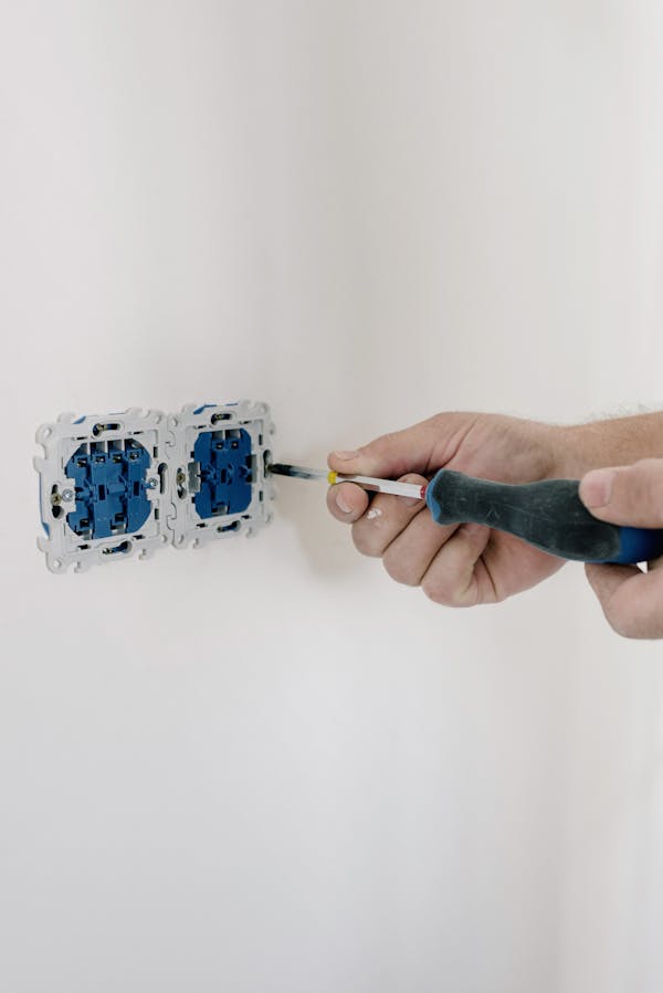 Elektrikář při opravě a instalaci elektrických zásuvek